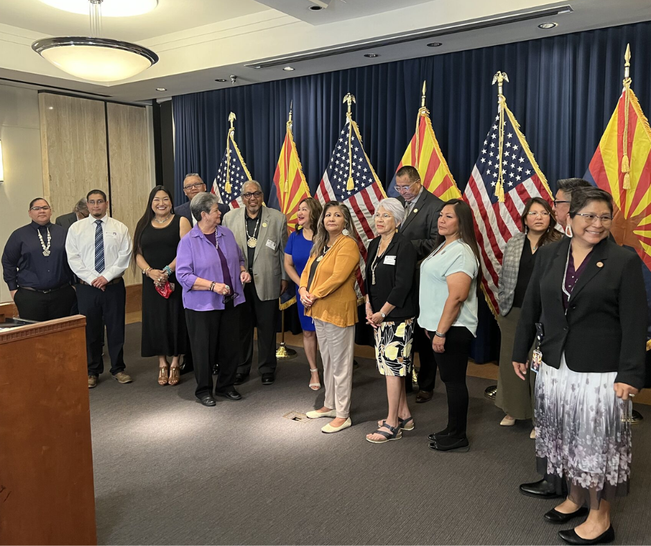 Tribal Leaders from AZ standing behind podium in front of flag at a press conference